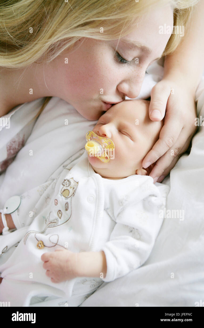 13 year-old girl attends her newborn brother in the hospital Stock Photo