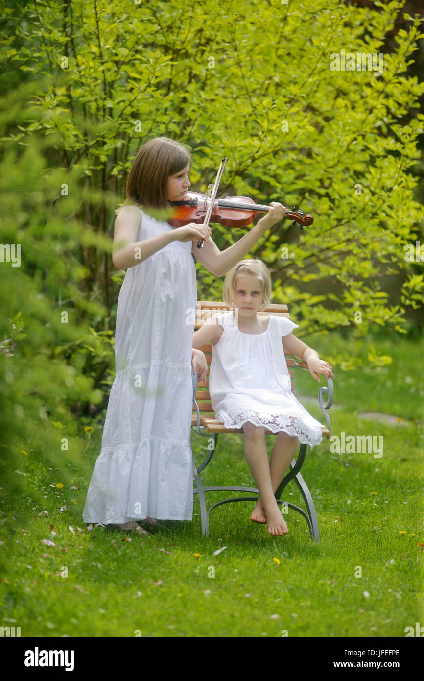 Two girls in the garden, 7 and 10 years old, Stock Photo