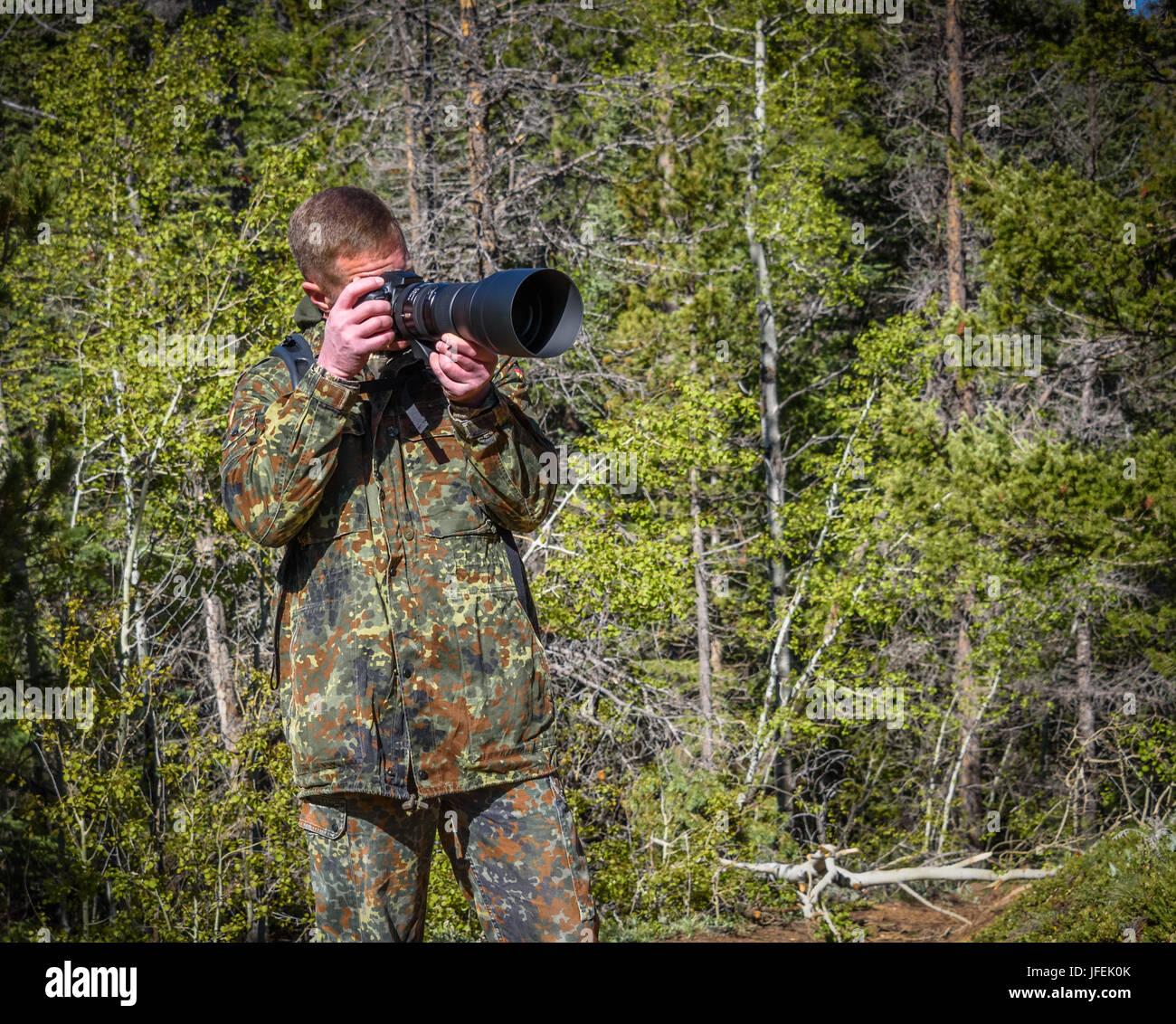 Wildlife, nature man photographer in camouflage outfit shooting, taking pictures Stock Photo