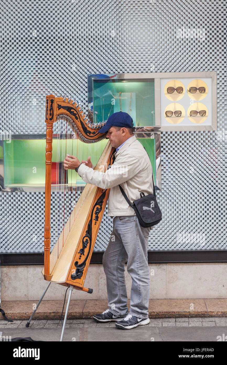 England, Manchester, Busker Playing Harp Stock Photo