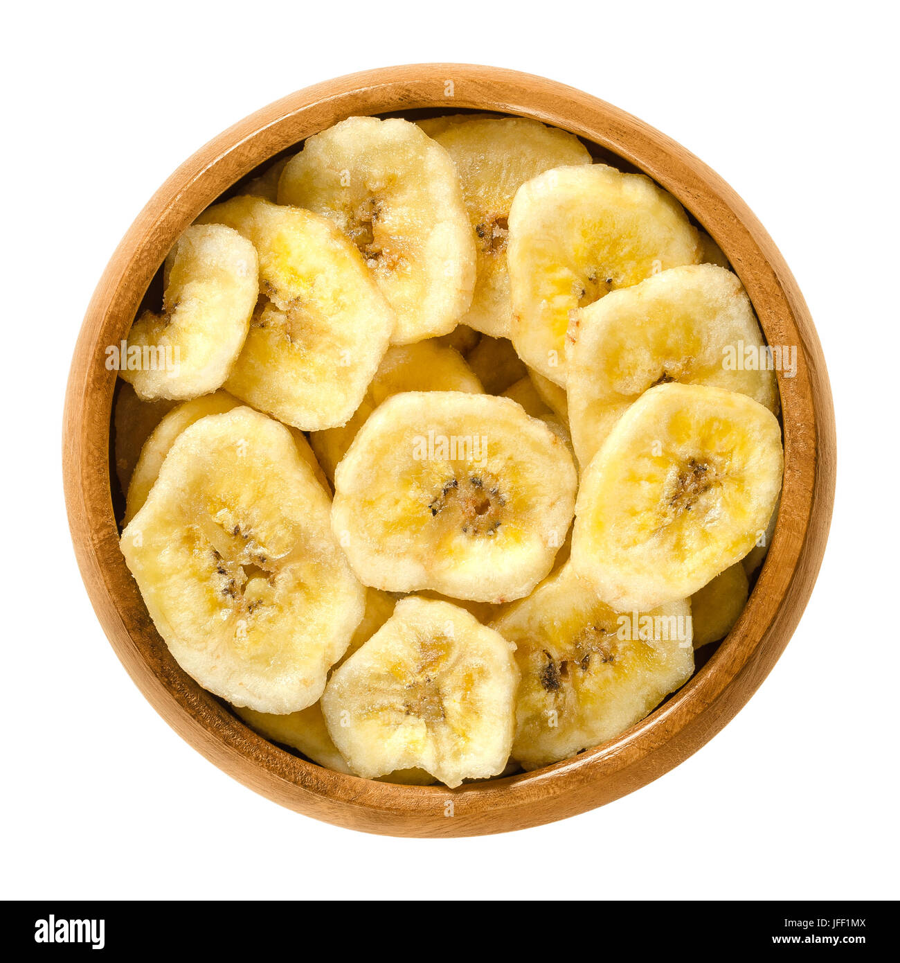 Dried banana chips in wooden bowl. Yellow deep fried slices of bananas, covered with sugar or honey. Snack with sweet taste. Isolated macro food photo Stock Photo