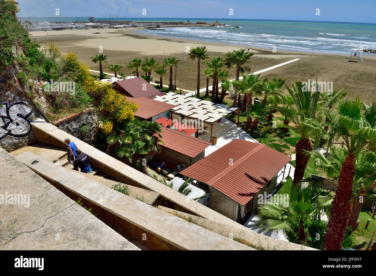 Looking down steps to nearly deserted beach on a windy summer day in Anzio, Italy Stock Photo