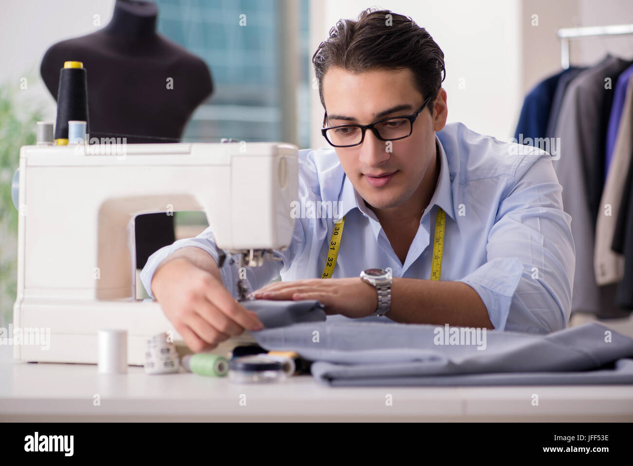 Young man tailor working on new clothing Stock Photo - Alamy