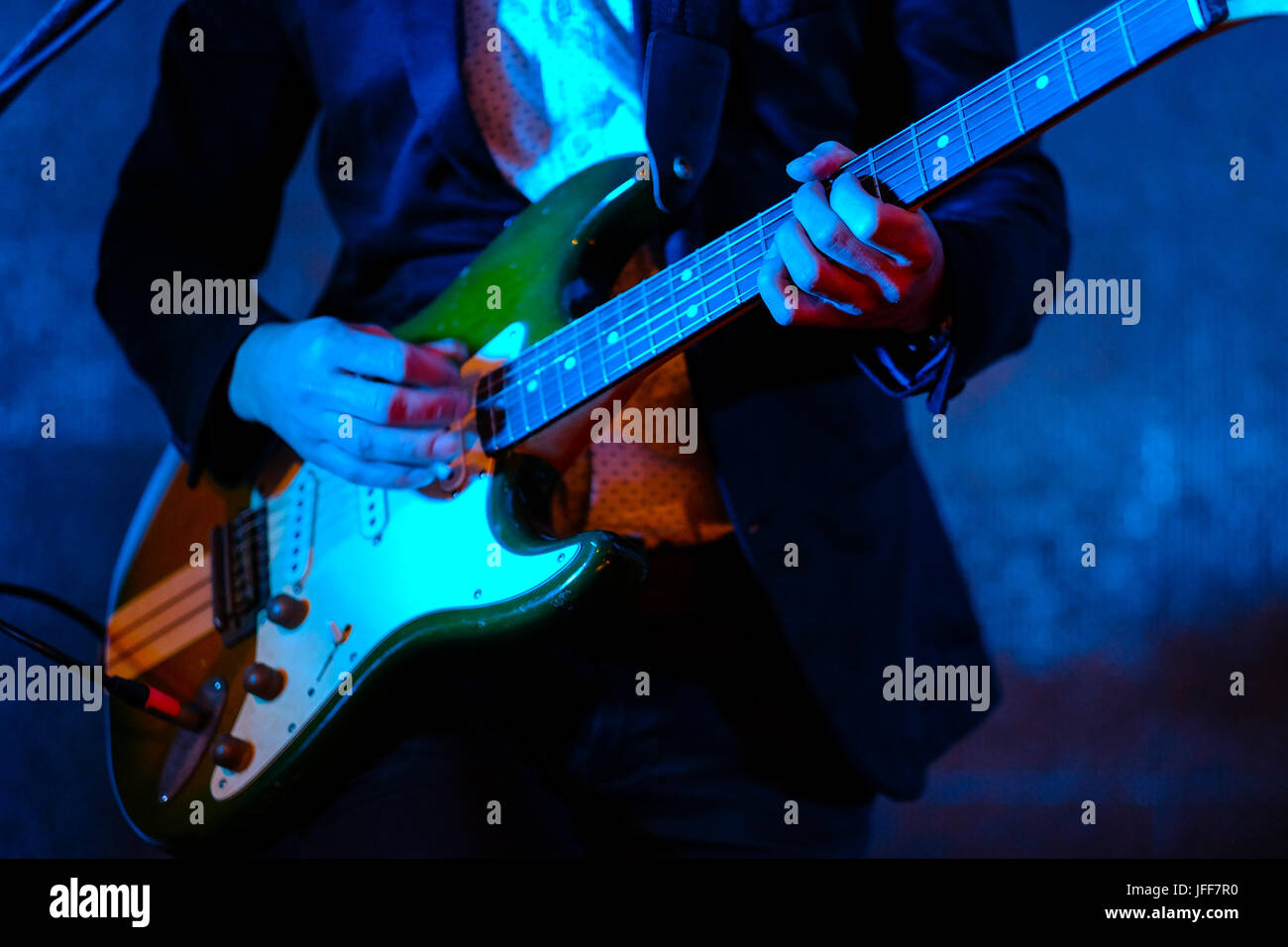 Close up of a musician playing the electric guitar during a concert Stock Photo