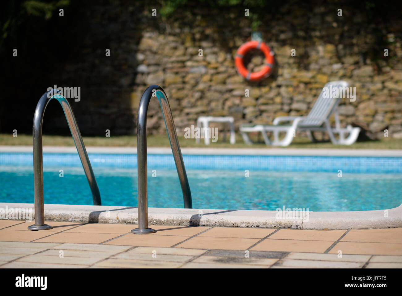 Outdoor swimming pool entry ladder Stock Photo