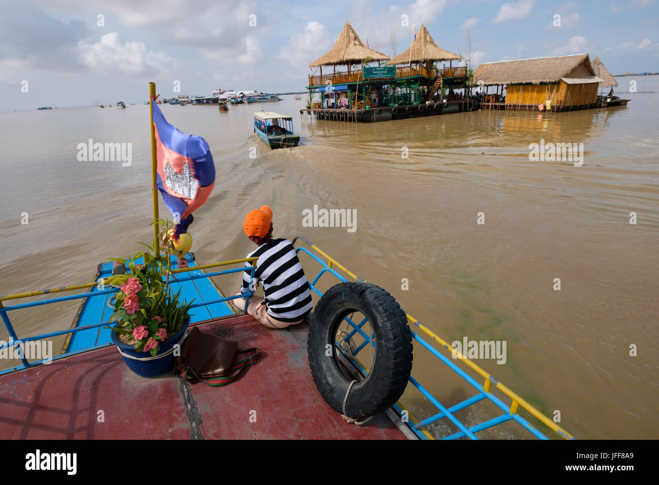 Boat next to a building on a floating village in the Mekong river ...