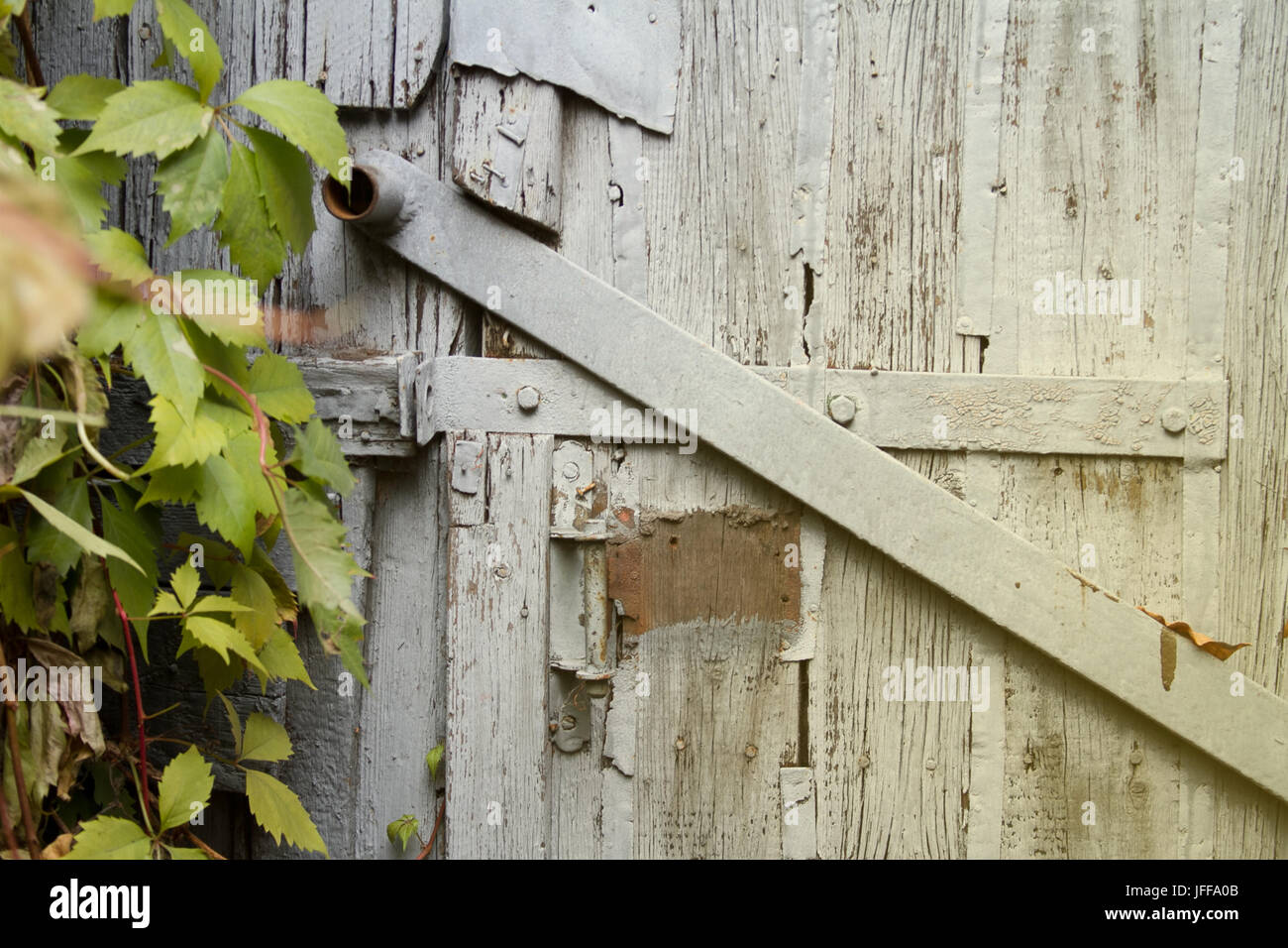 Fragment of old wooden door with rusty handle. Stock Photo