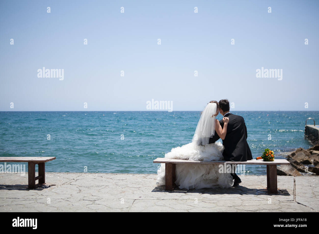 Couple Smiling And Embracing Near Wedding Arch On Beach Honeymoon