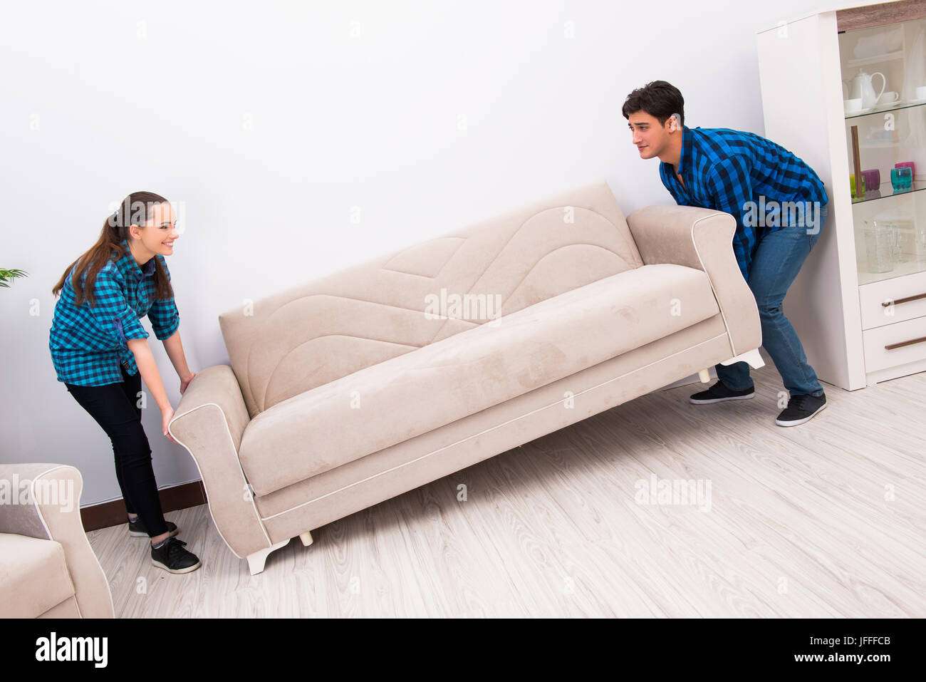 Wife and husband moving sofa couch Stock Photo Alamy