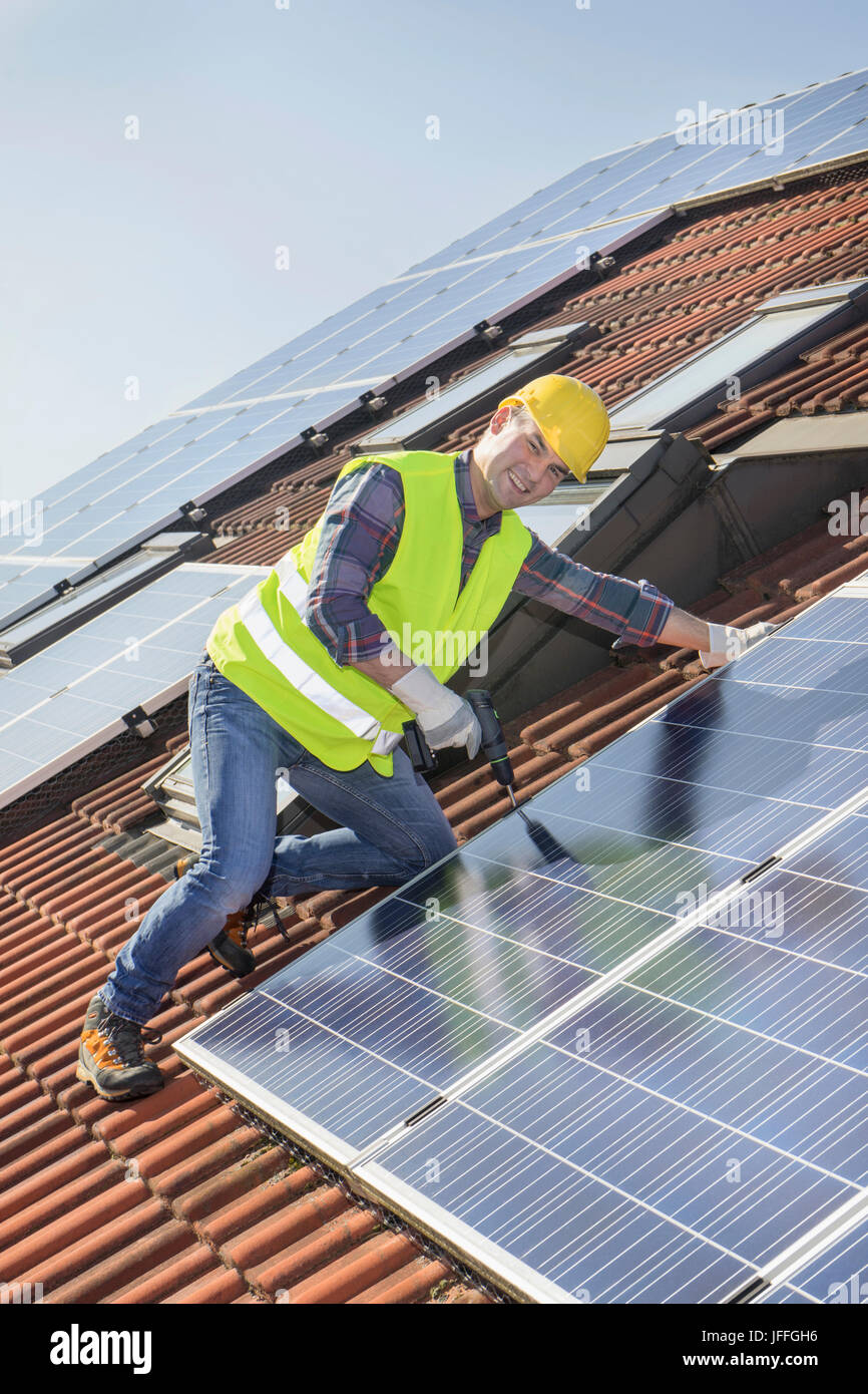 Engineer fitting solar panels to roof of house Stock Photo Alamy