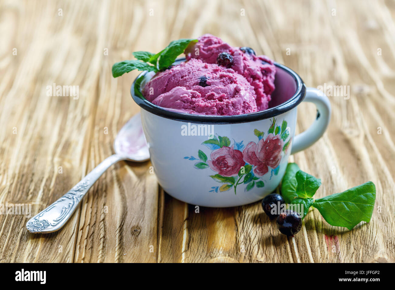 Berry ice cream and mint in enamel mug. Stock Photo