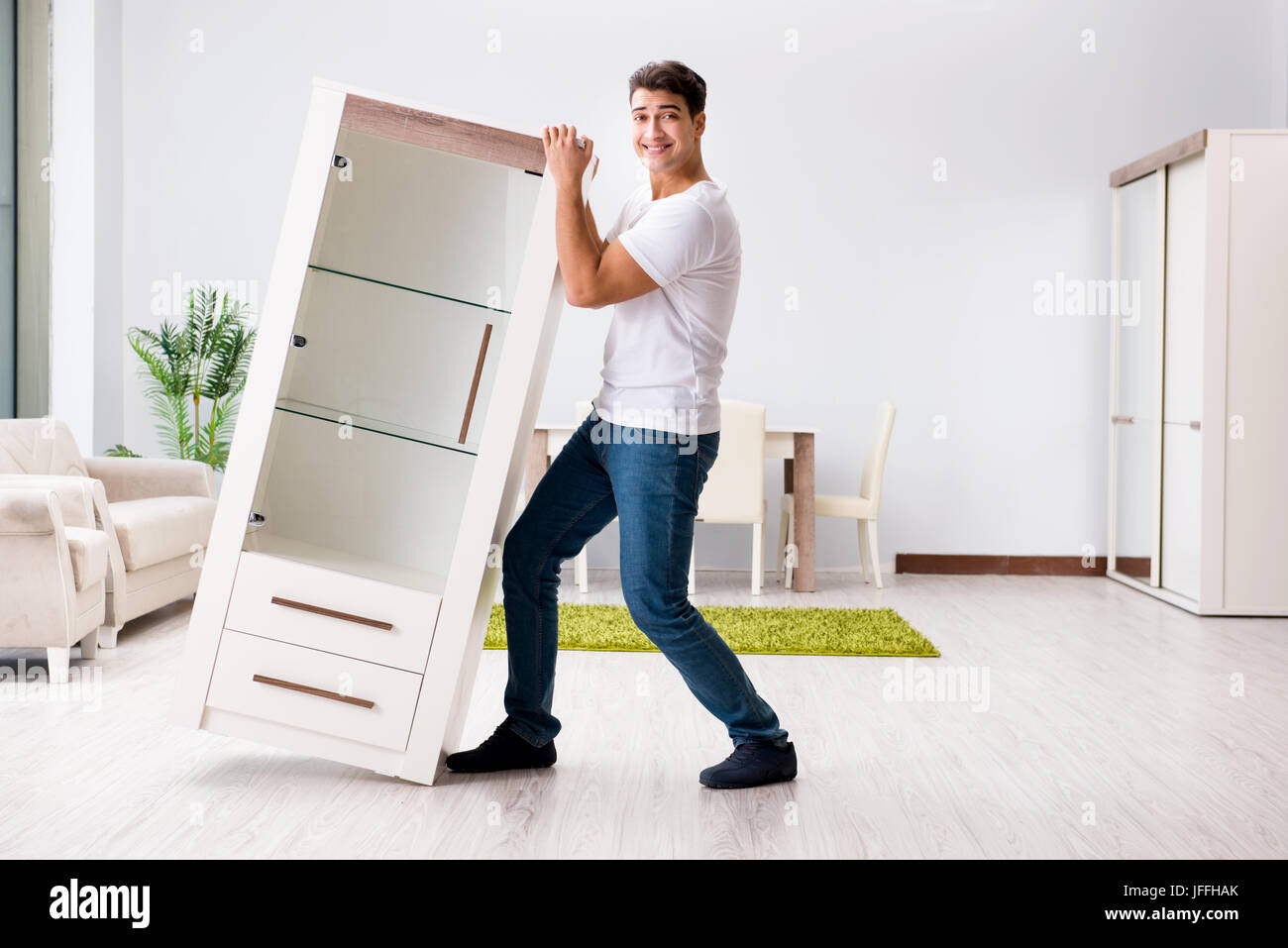 Young man moving furniture at home Stock Photo Alamy