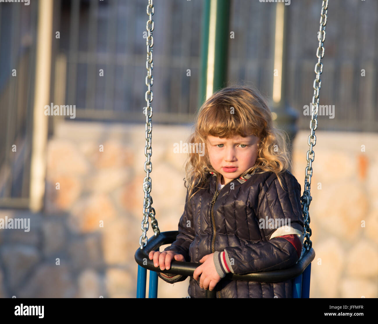 Adorable boy on a swing near the house Stock Photo