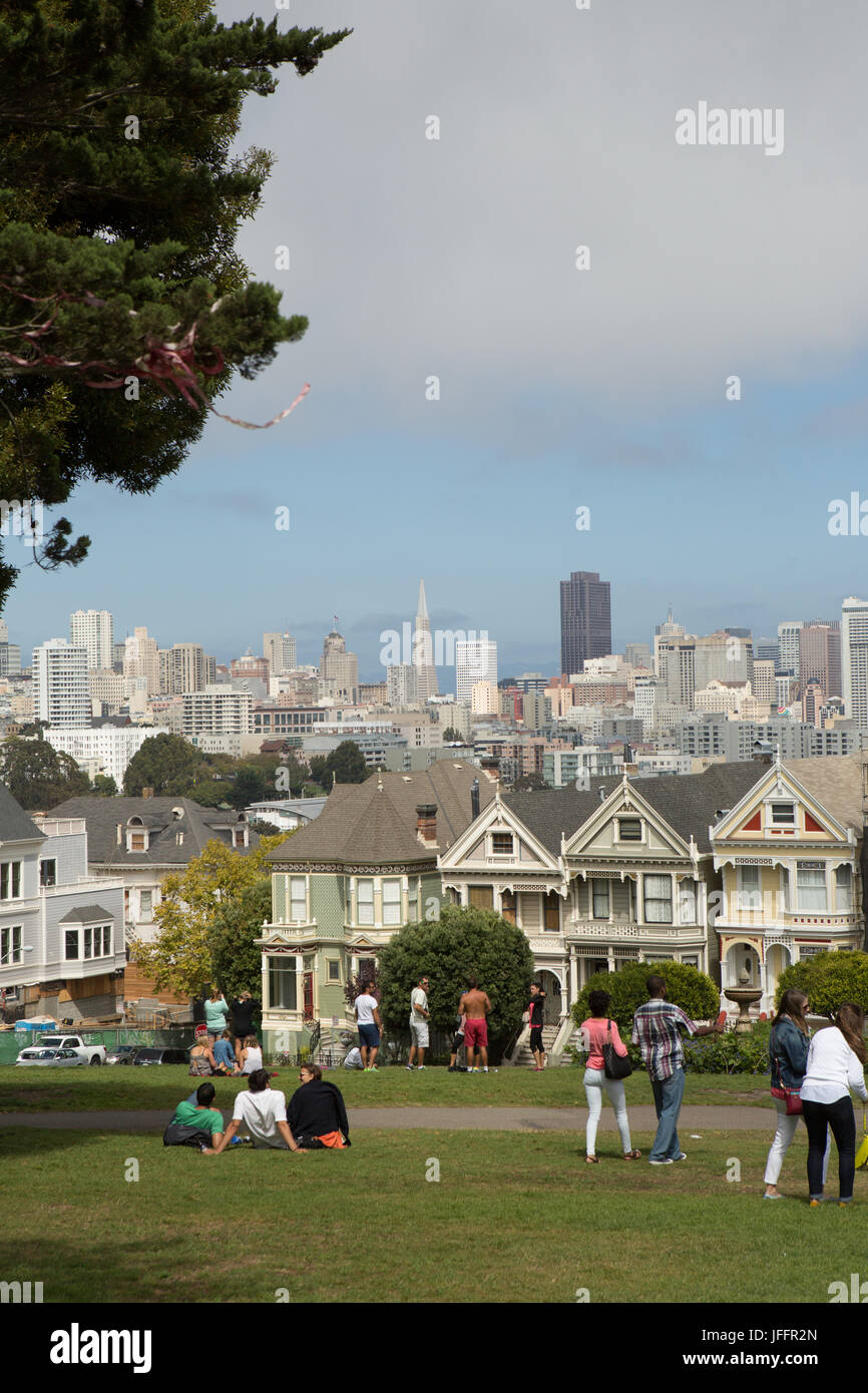 People gathered in a park in downtown San Francisco near the famous row of houses called the Painted Ladies. Stock Photo