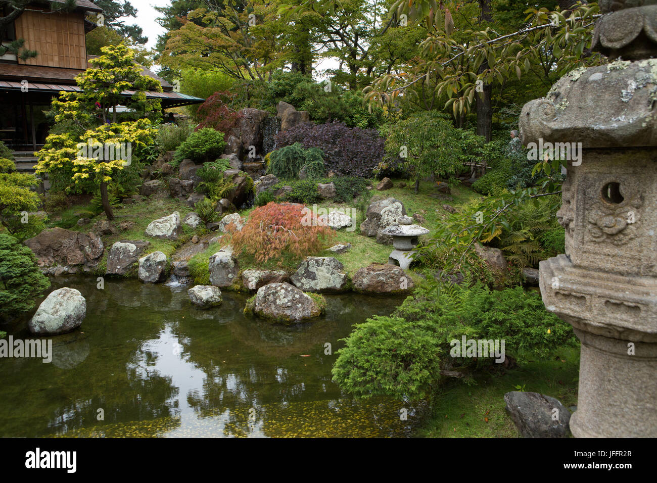 A scenic view of a pond, rock garden, sculpture and Japanese architecture in San Francisco's Japanese Tea Garden. Stock Photo