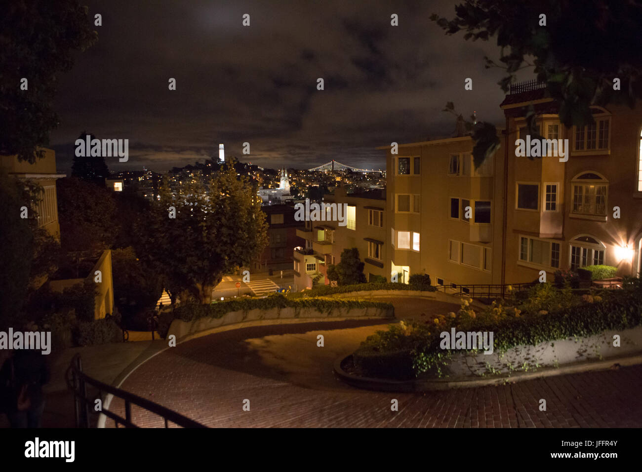 A view of the Coit Tower and the San Francisco Bay Bridge, from Lombard Street, the most crooked street in downtown San Francisco. Stock Photo