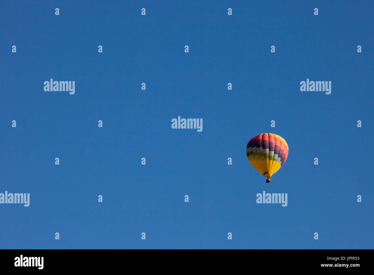 A hot air balloon flying in a clear, blue sky. Stock Photo