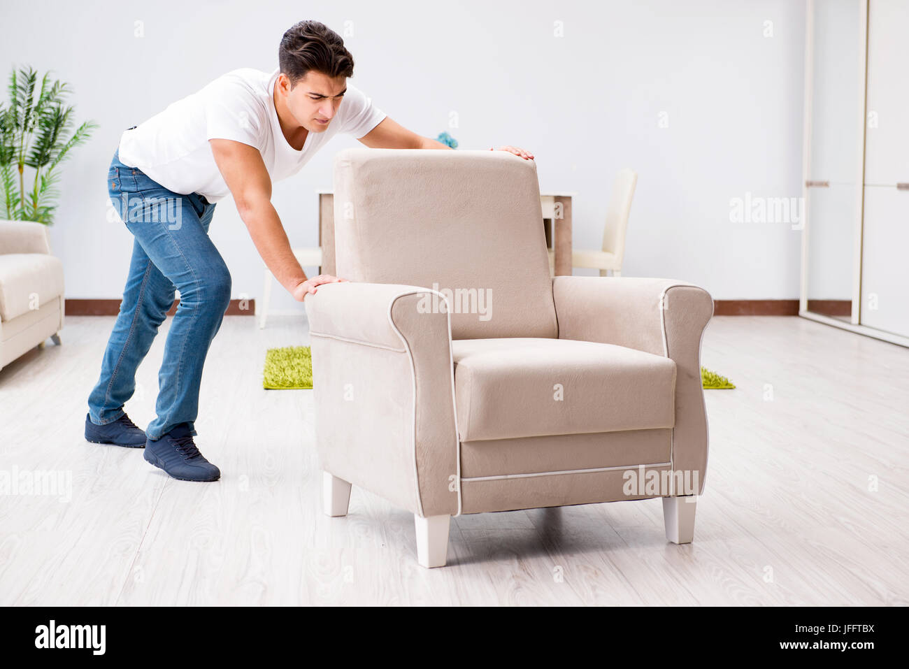Young man moving furniture at home Stock Photo Alamy