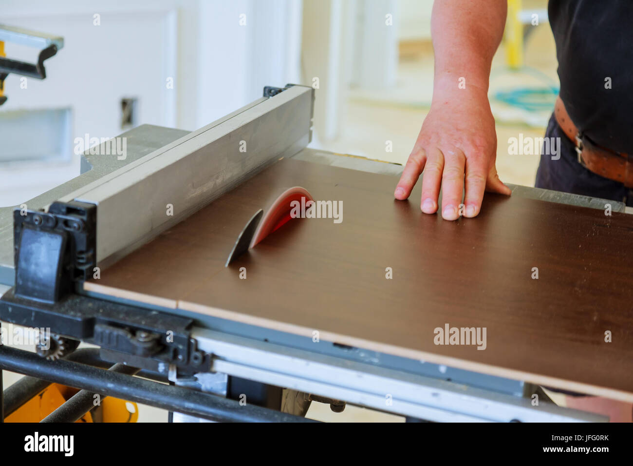 Carpenter using table saw cutting wood. handyman cutting plywood on