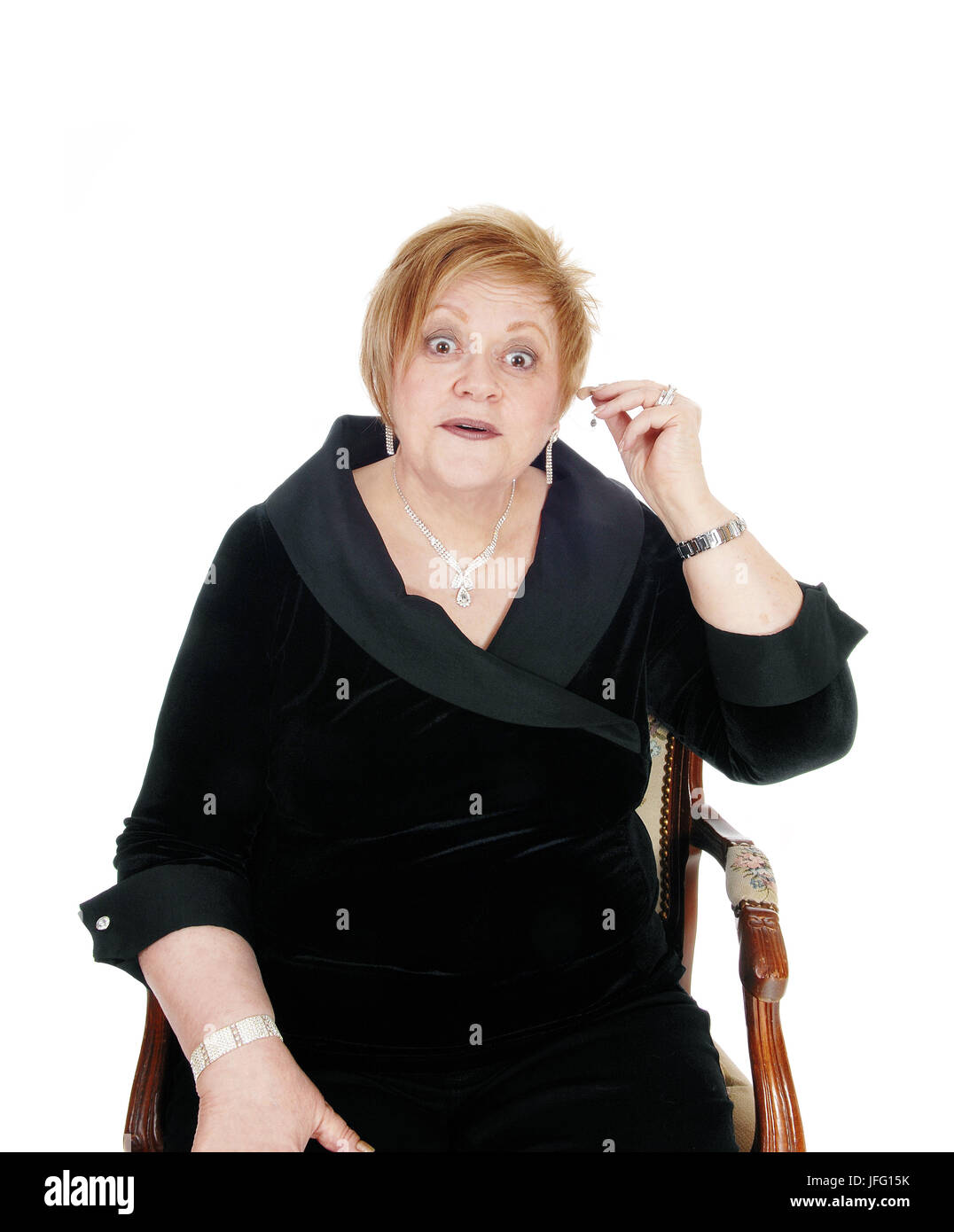 Senior woman putting hearing aid on. Stock Photo