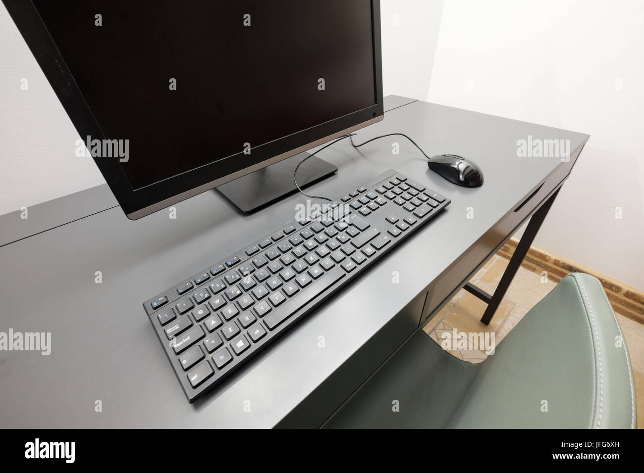 Desktop computer with monitor, keyboard and wired mouse on a desk Stock Photo