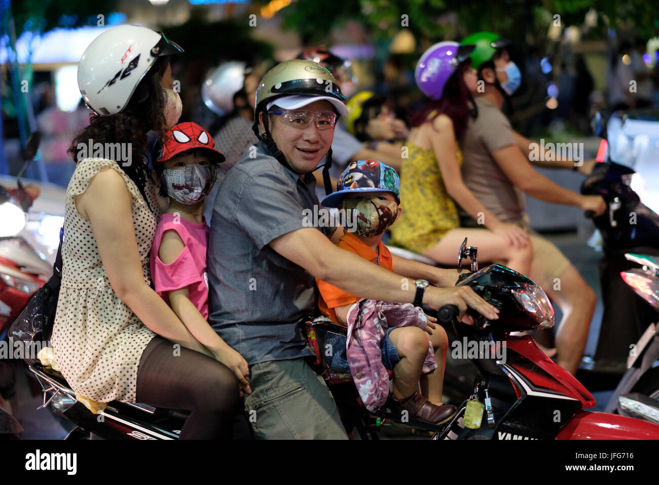 Entire family riding a scooter on the streets of Ho Chi Minh City in Vietnam, Asia Stock Photo