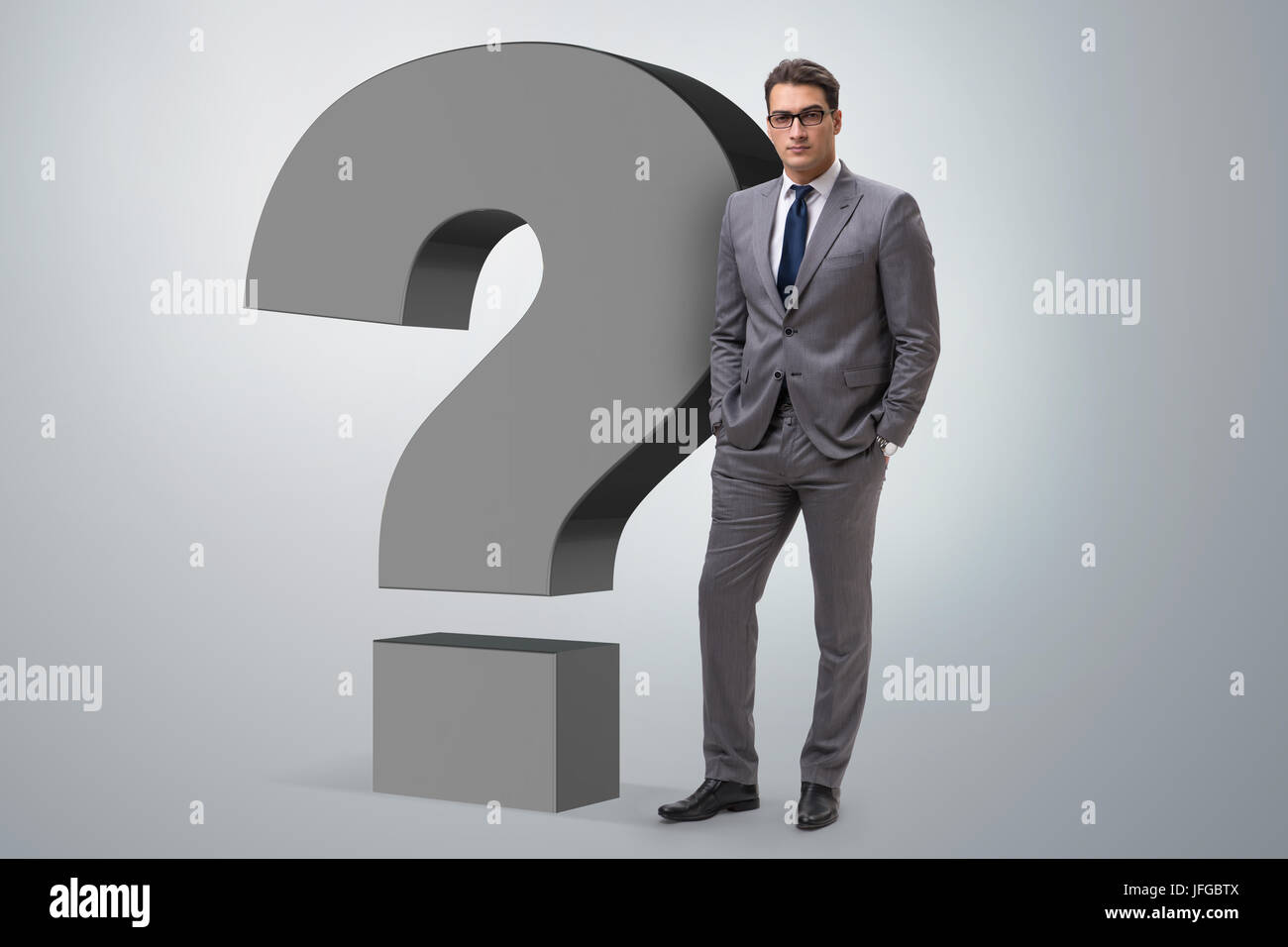 Businessman next to the giant question mark Stock Photo