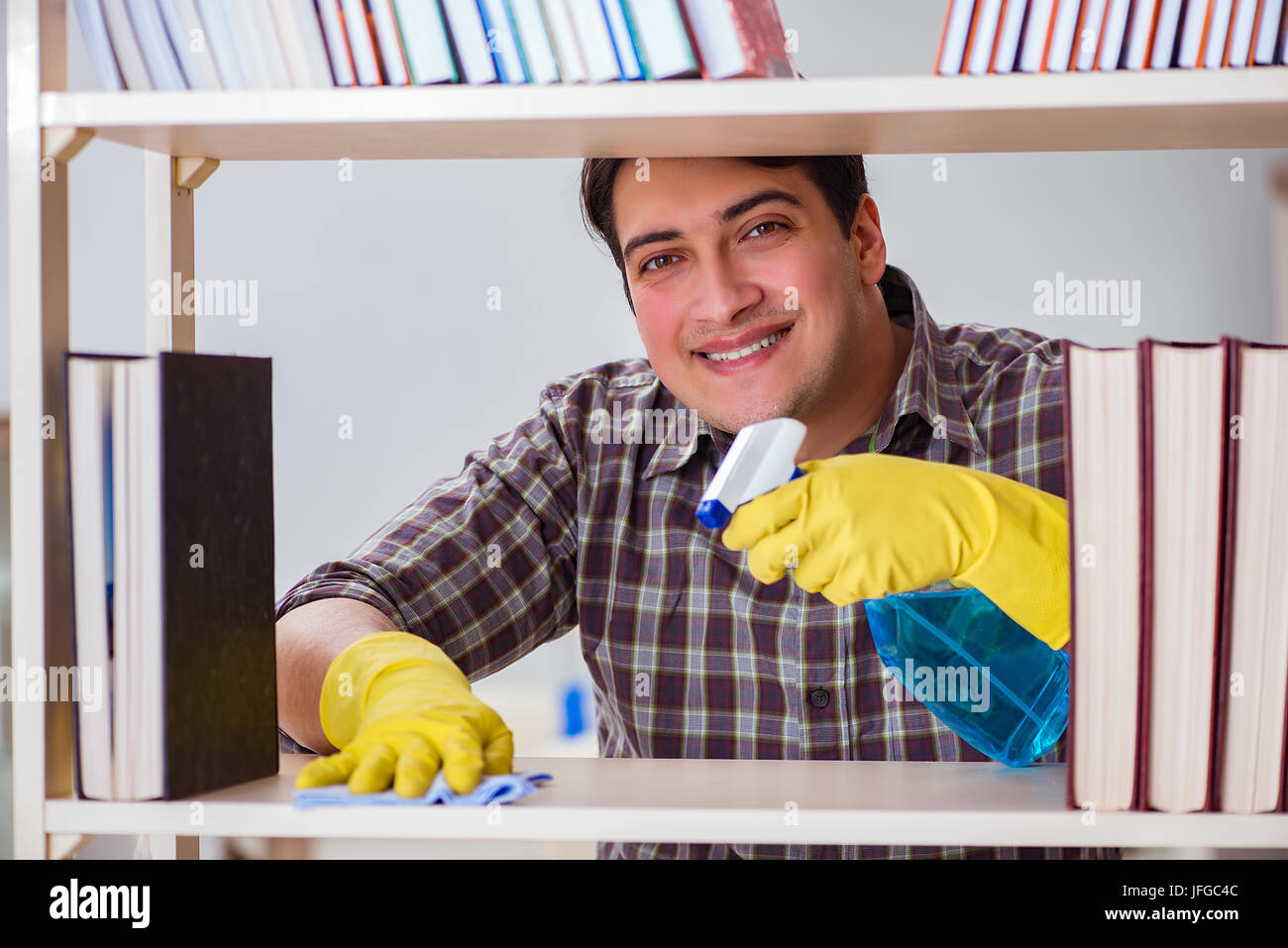 Man cleaning dust from bookshelf Stock Photo Alamy