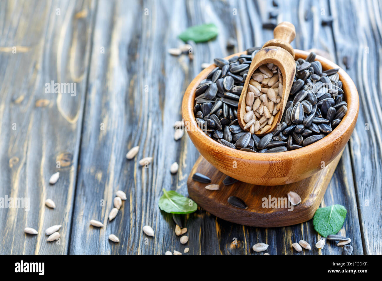 Sunflower seeds and a scoop in wooden bowl. Stock Photo