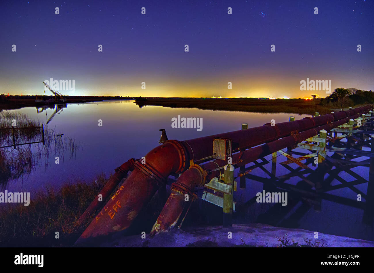 industrial pipes and ocean harbor landscape at night Stock Photo