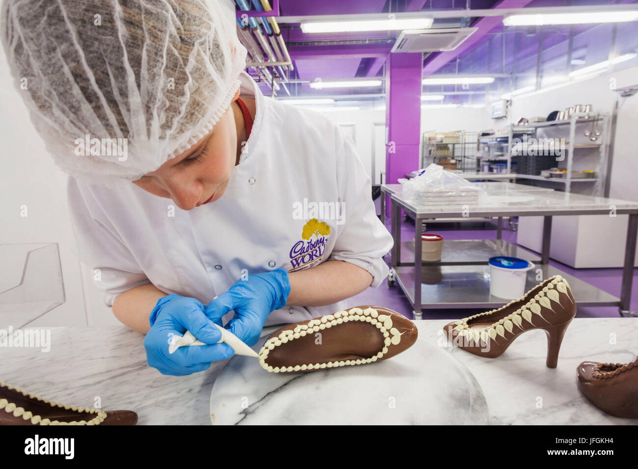 England, Birmingham, Bournville, Cadbury World, Woman Decorating Chocolate Shoe Stock Photo