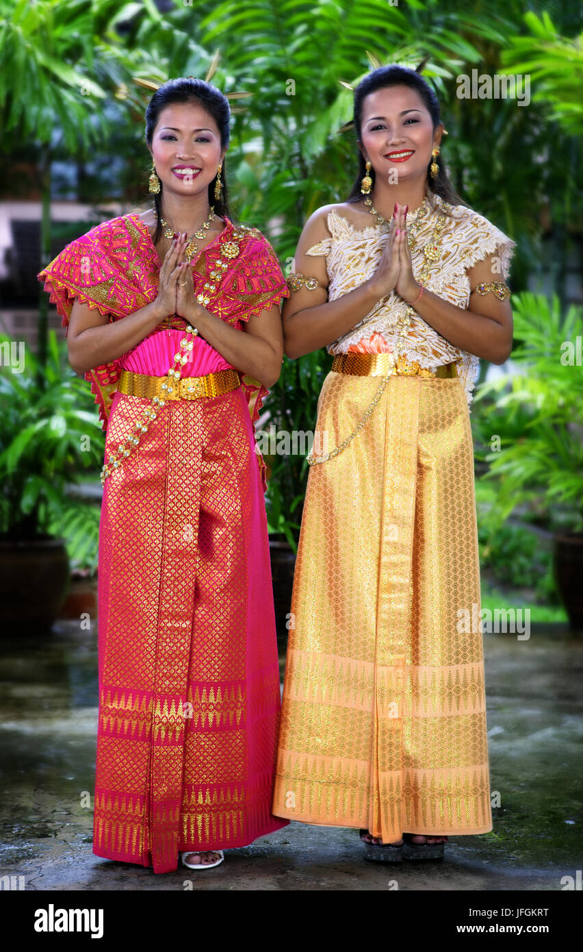 Two Thai woman keeping hands in traditional welcome sign. Phuket, Thailand. 18, 19, 20, 21, 24, 25, 29, 30, 31, 34, 35, 39, years old Stock Photo