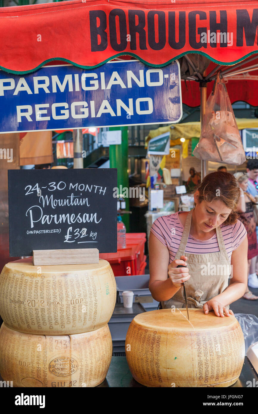 England, London, Southwark, Borough Market, Female Vendor Cutting Cheese Stock Photo