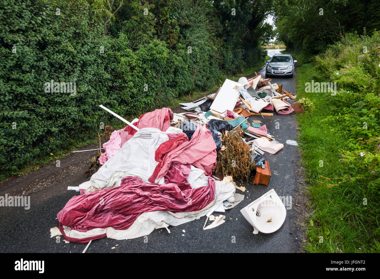 England, Sussex, Fly Tipping on Small Rural Road Stock Photo