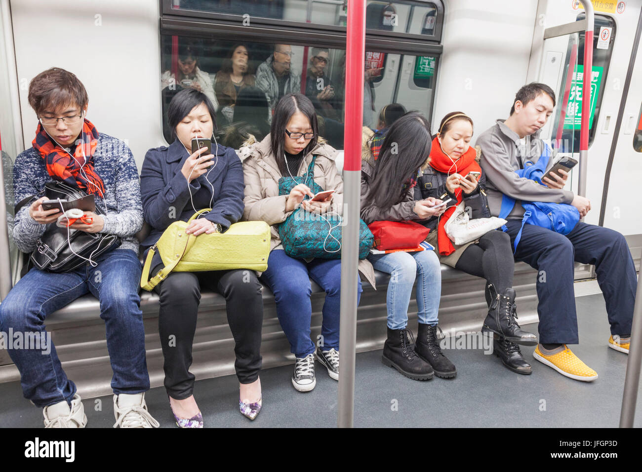 China, Hong Kong, Subway Passengers Using Electronic Devices Stock Photo