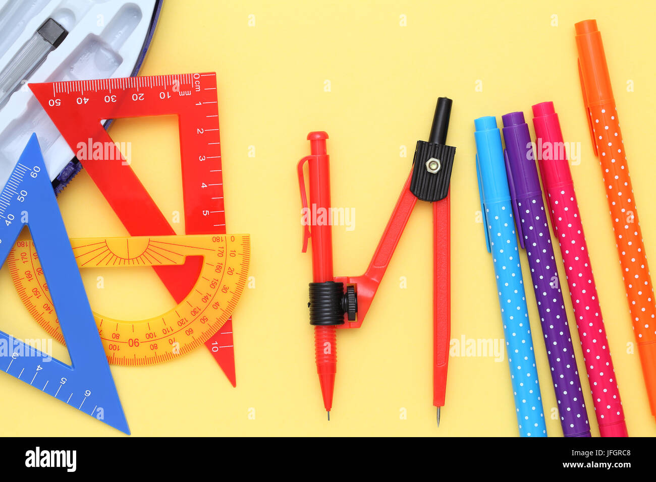Multicolored rulers and pen on yellow background Stock Photo - Alamy