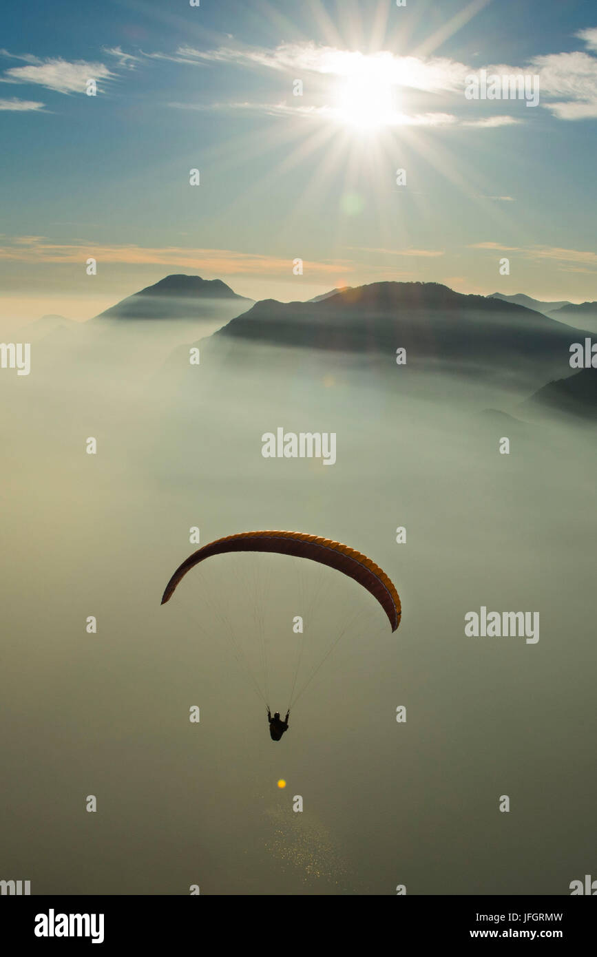Paraglider about Gardasee, aerial picture, sea of clouds, inversion weather condition, Malcesine, Veneto, Italy Stock Photo