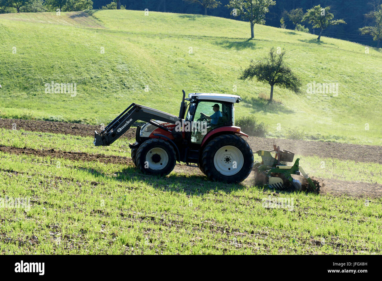 Tractor on field, peninsula Bodanrück, Lake of Constance, Baden-Wurttemberg, Germany Stock Photo