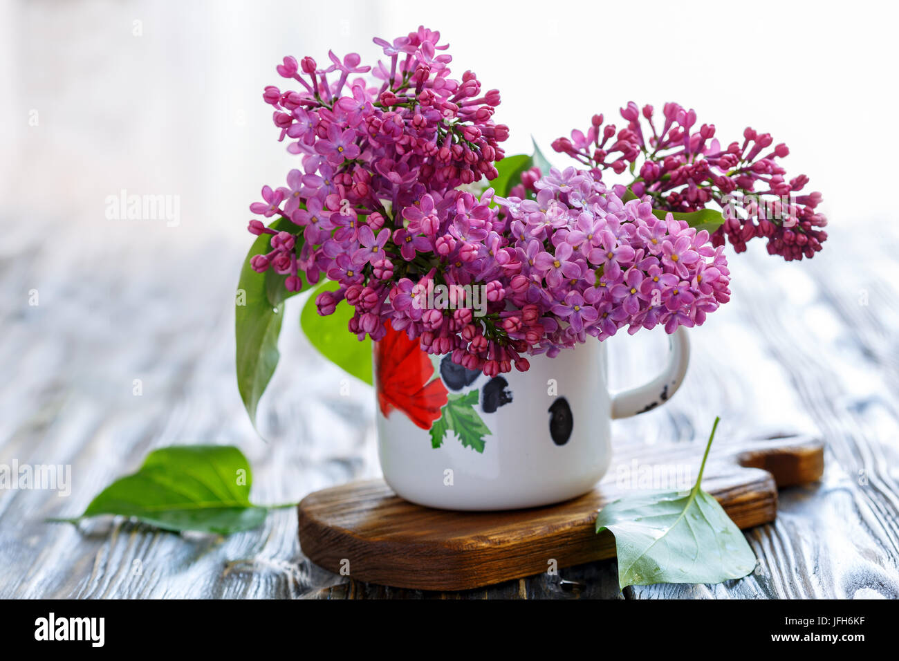 Bouquet of lilacs in an old enamel mug. Stock Photo