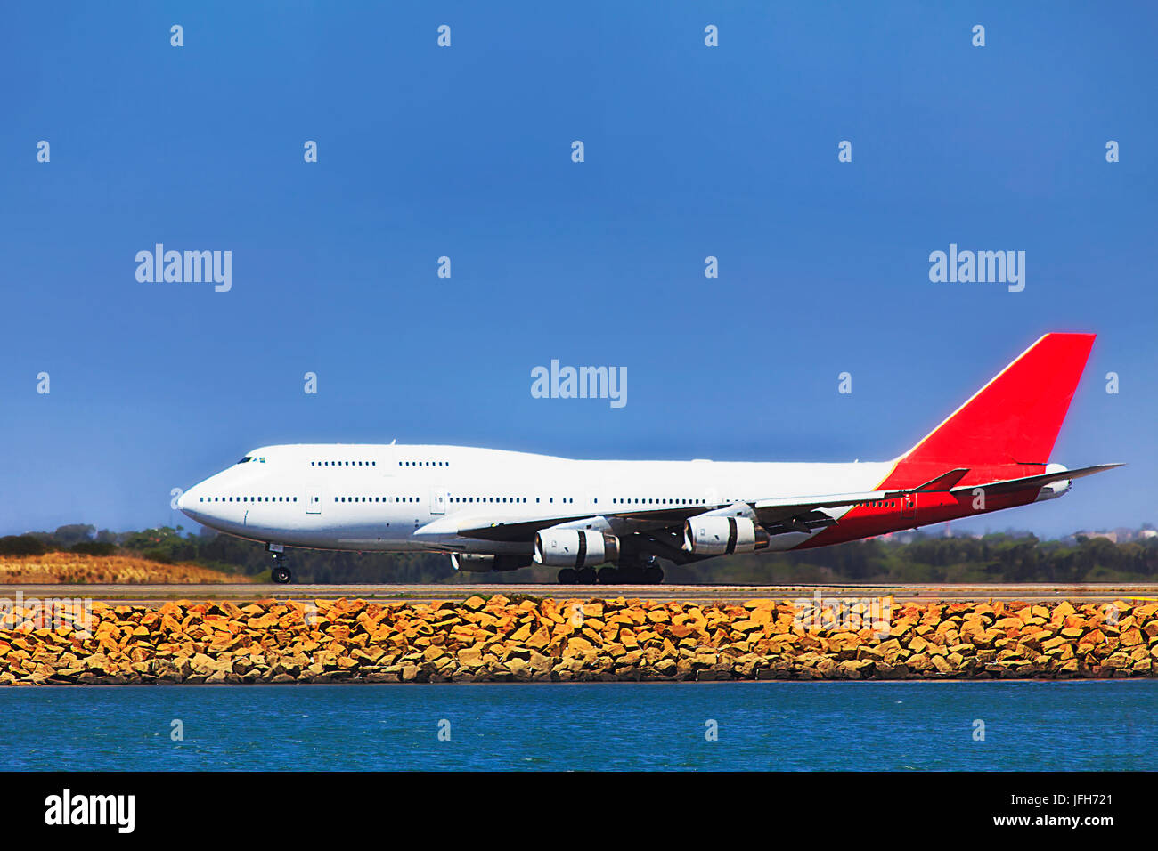 Double decker modern air jet taking off from Sydney internation airport runway on a bright sunny day under blue clear sky. Stock Photo