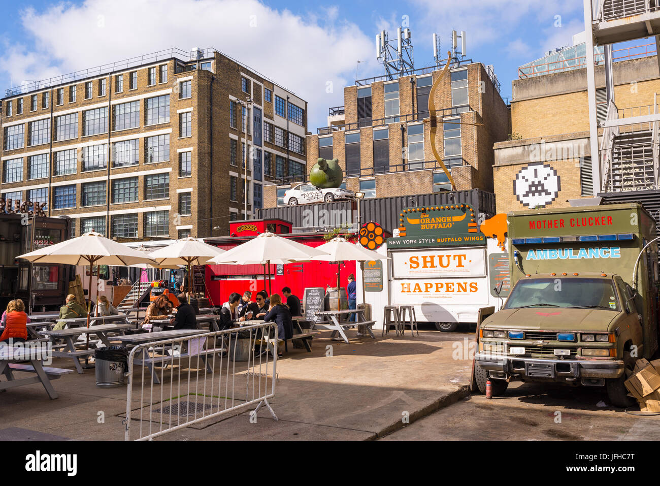 Pop up outdoor restaurants with people eating outiside at The Old Truman Brewery, Ely's Yard, Shoreditch, London, UK Stock Photo