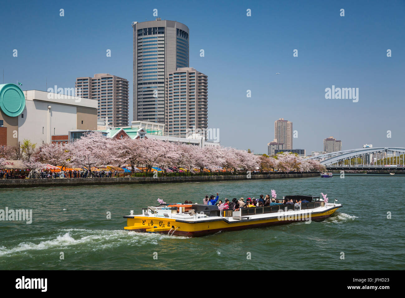 A sightseeing tour boat on the Okawa River near The Mint in Osaka, Japan. Stock Photo