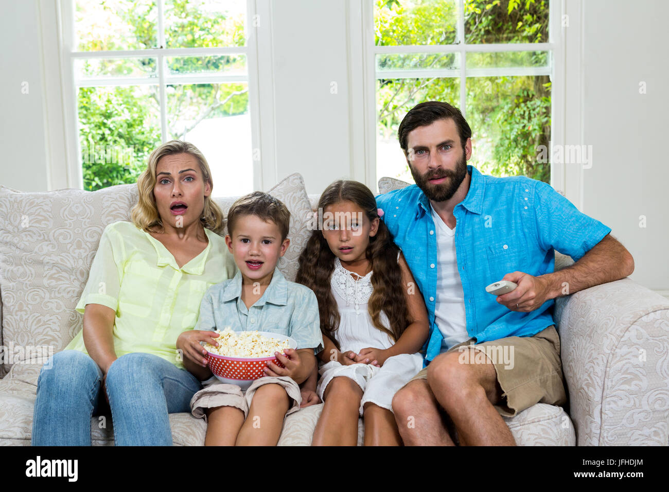 Portrait of surprised family laughing while watching tv Stock Photo