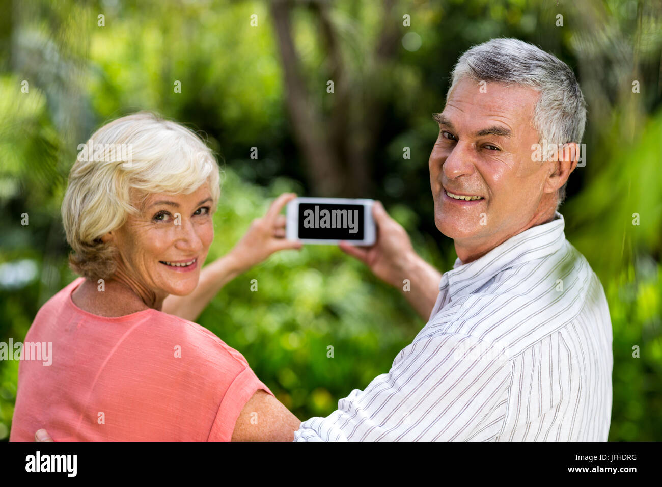 Senior couple taking selfie while standing in yard Stock Photo - Alamy