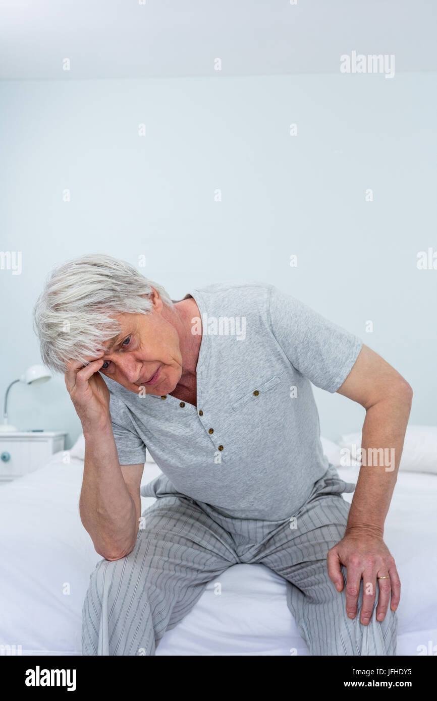 Senior man suffering from headache while sitting at home Stock Photo ...