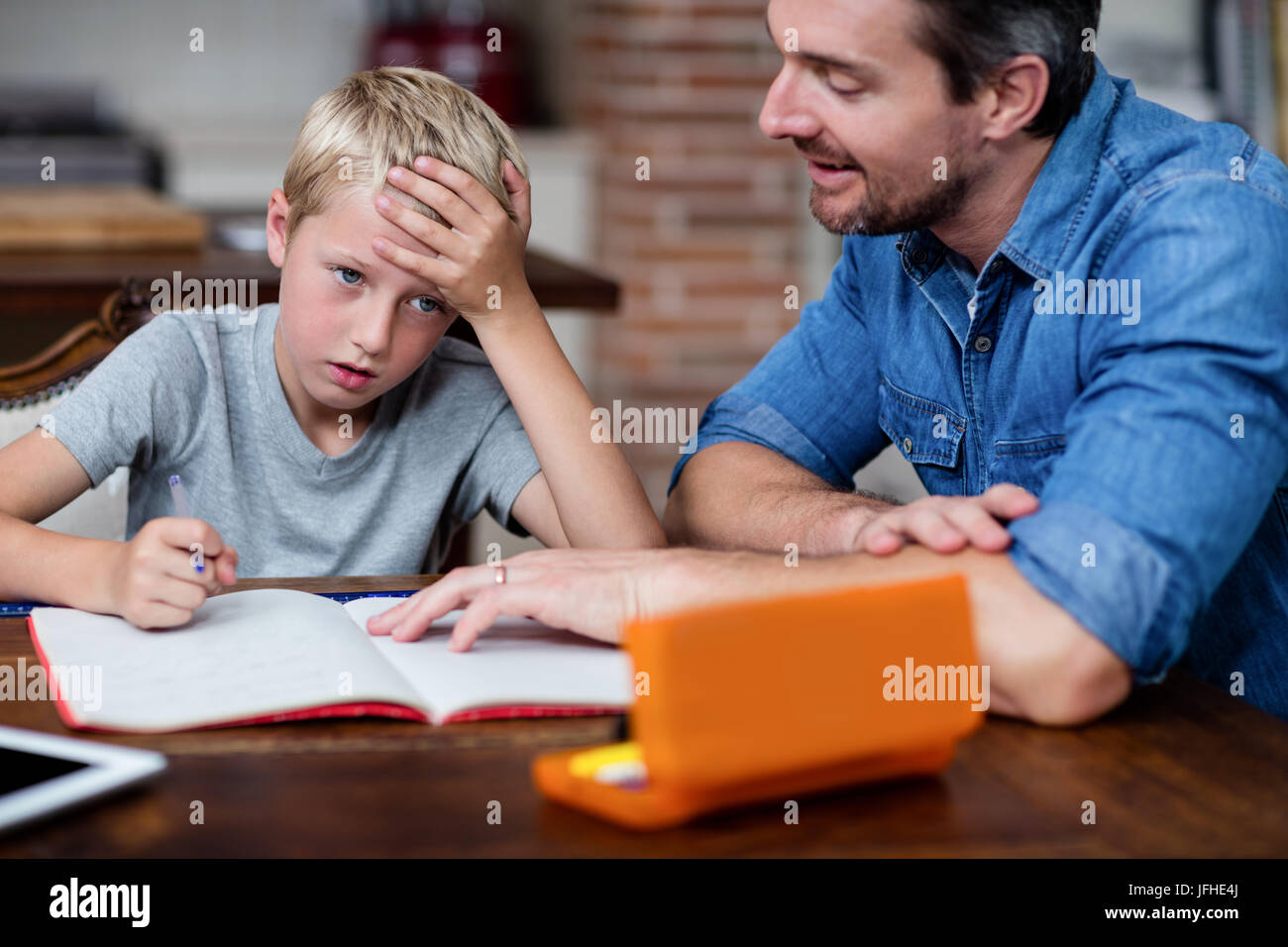 Father helping son with his homework in kitchen Stock Photo - Alamy