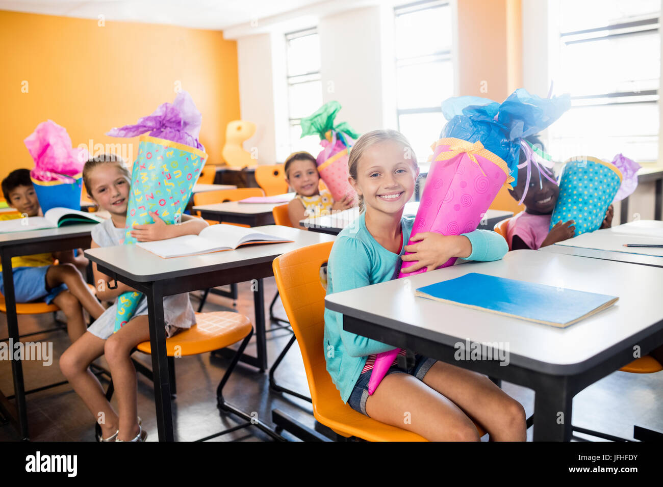 happy pupils sitting at their desk with gifts boxes Stock Photo - Alamy