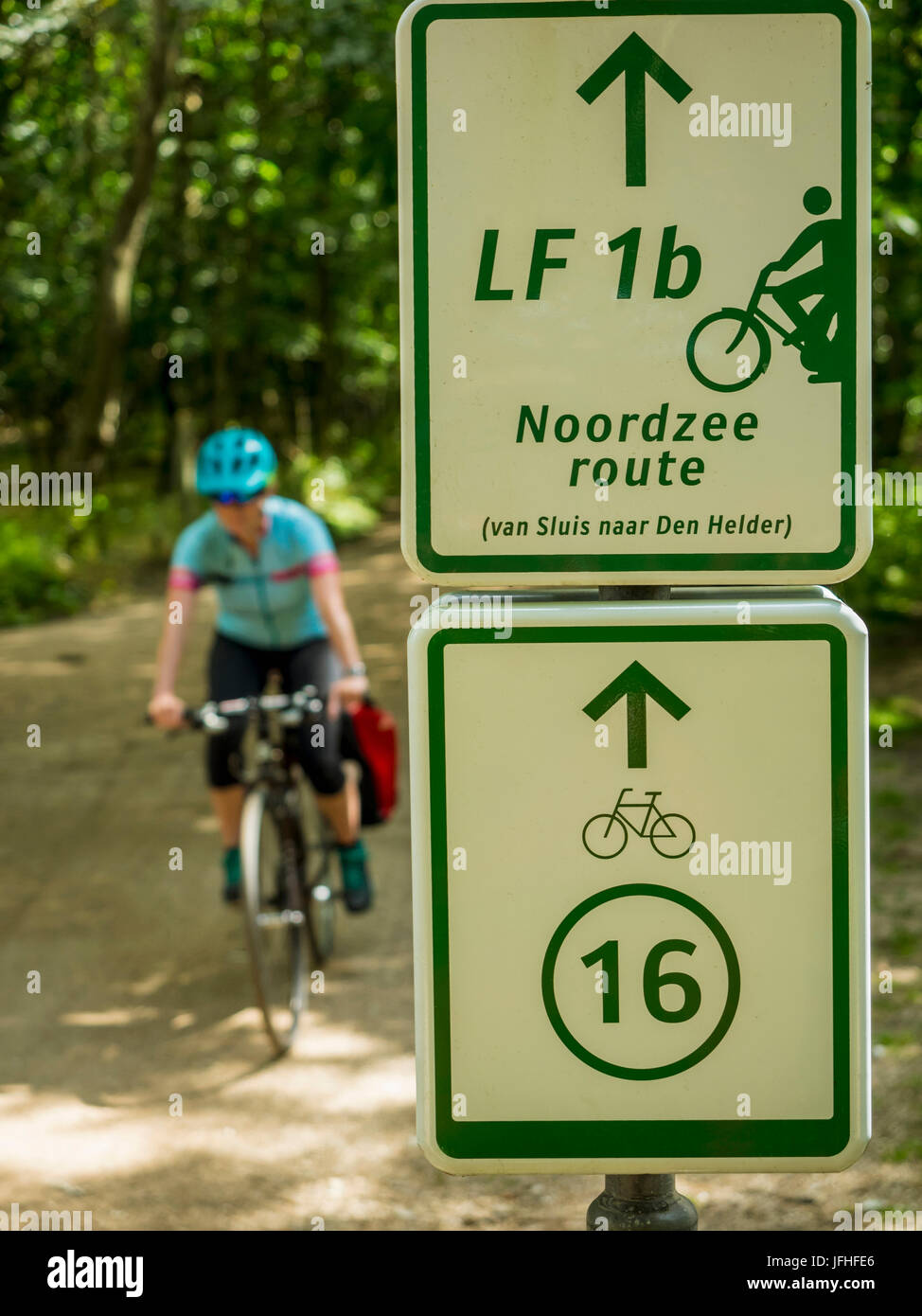 Close-up of bicycle sign and cyclist riding Stock Photo