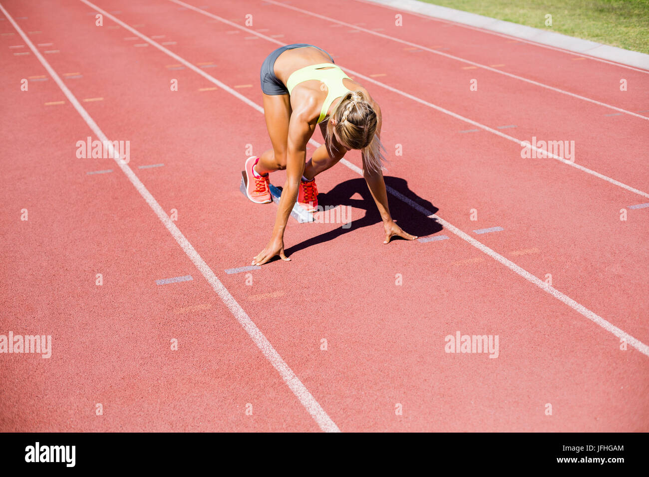Female athlete ready to run on running track Stock Photo