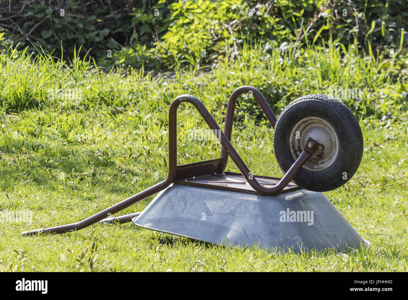 Wheelbarrow lying on a meadow Stock Photo